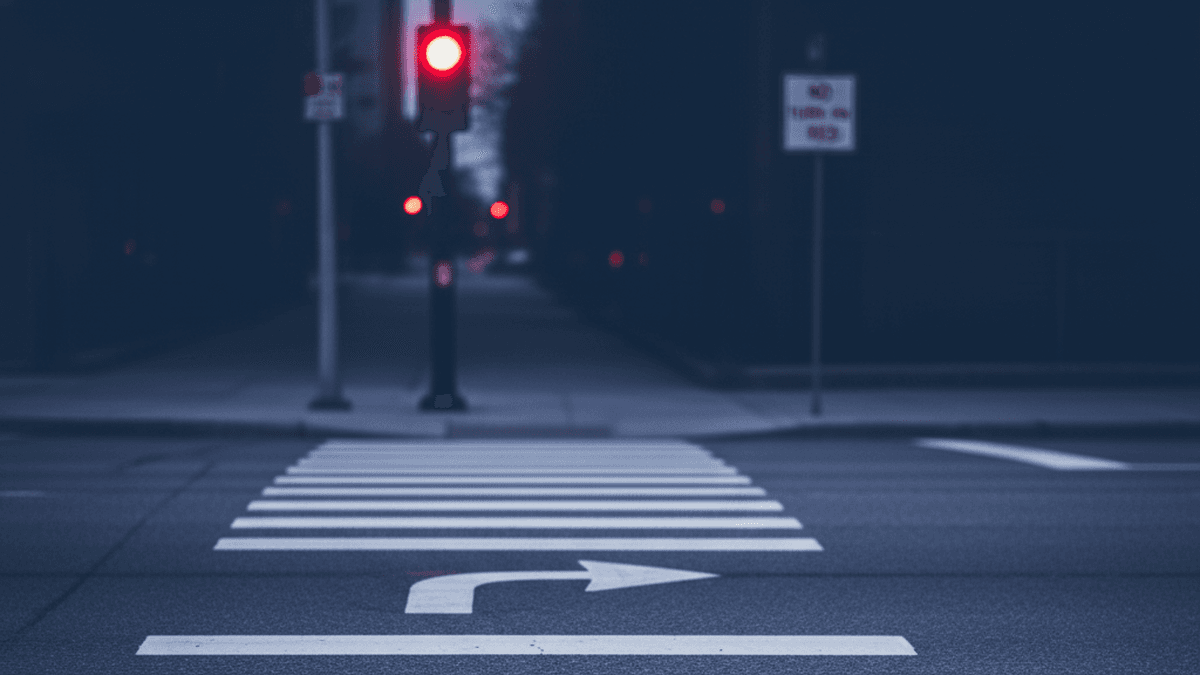 Red traffic signal with a right-turn arrow marking and a blurred 'No Turn on Red' sign in the background